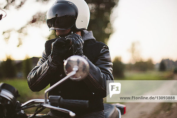 Verstellbarer Helm für männliche Motorradfahrer auf dem Motorrad sitzend