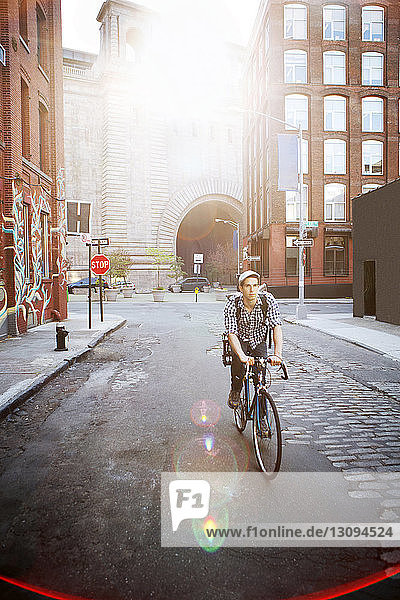 Mann fährt Fahrrad auf der Straße inmitten von Gebäuden