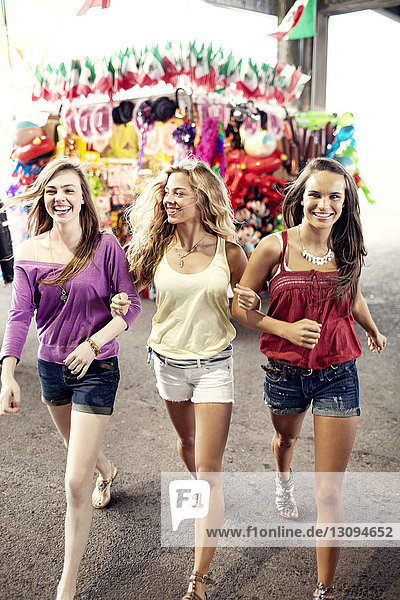 Cheerful female friends walking at amusement park