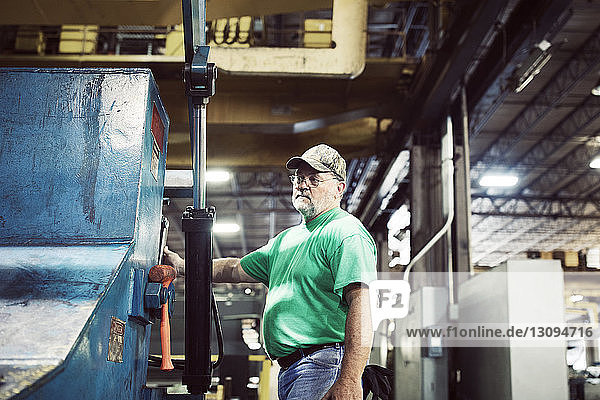 Worker using machine in steel industry