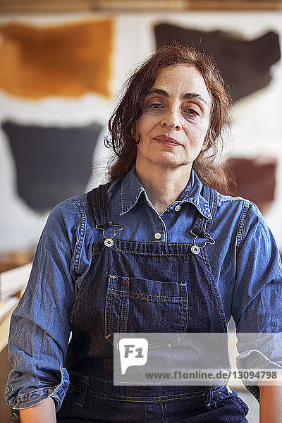 Portrait of confident female artist standing in workshop