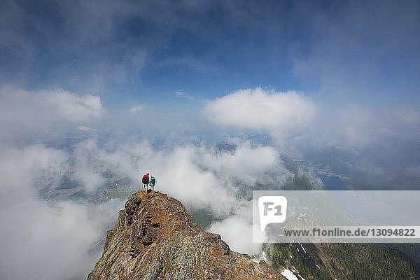 High angle view of hikers standing on Cheam Peak against sky amidst clouds