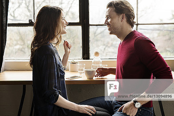Glückliches Paar schaut sich im Café von Angesicht zu Angesicht