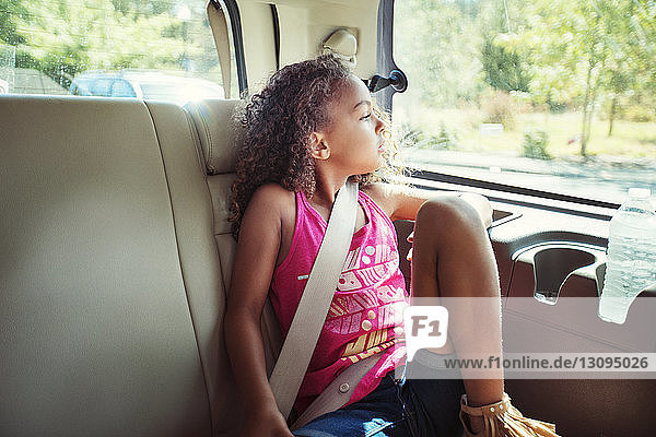 Mädchen schaut weg  während sie im Auto unterwegs ist