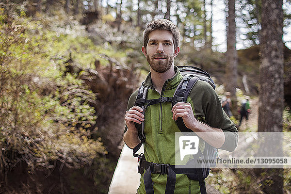 Portrait of hiker standing in forest