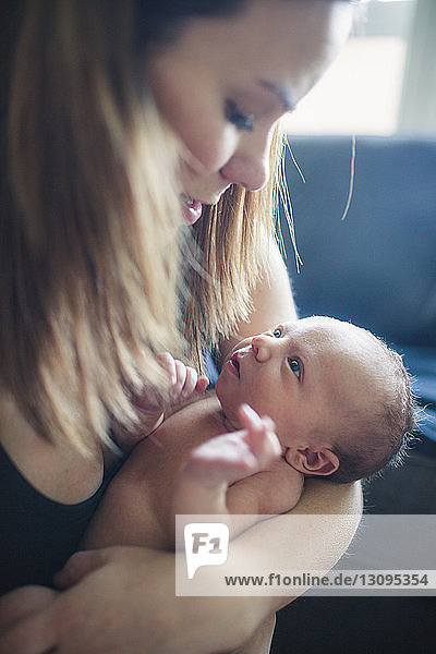 Loving mother holding newborn baby boy at home