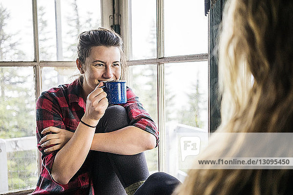 Frau genießt Kaffee in Hütte