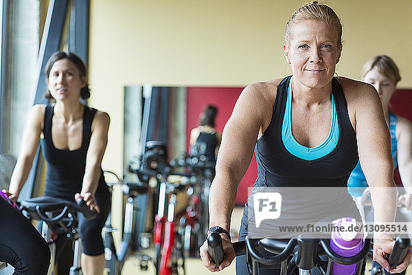 Frauen trainieren auf Heimtrainern im Fitnessstudio