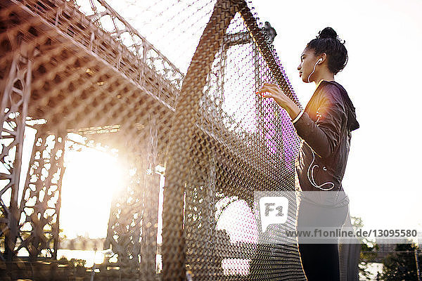 Junge Joggerin schaut an einem sonnigen Tag auf die Williamsburg Bridge