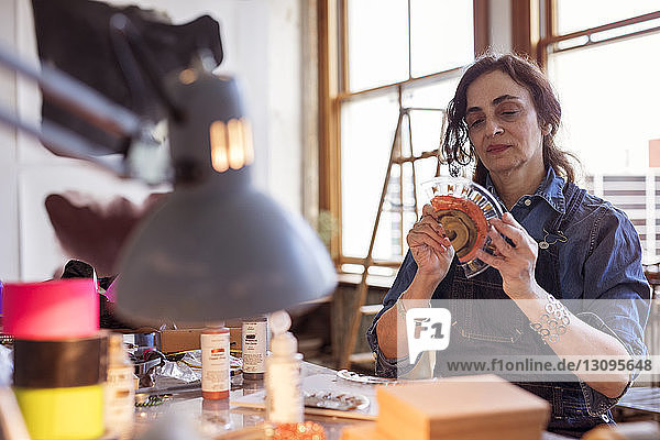 Female artist painting glass design in workshop