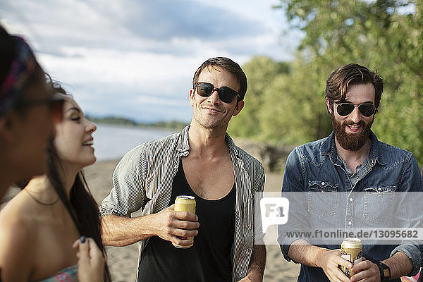 Happy friends having drinks at riverbank