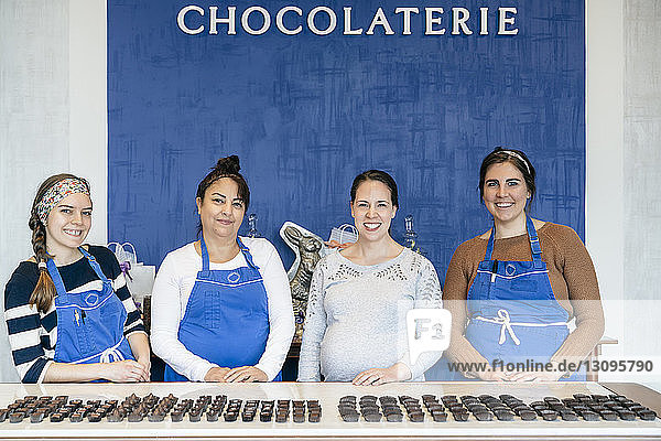 Porträt weiblicher Mitarbeiter  die bei Tafelschokolade im Laden stehen