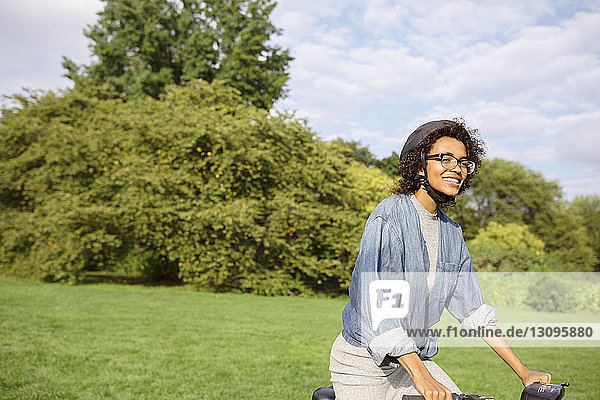Happy woman riding bicycle in park