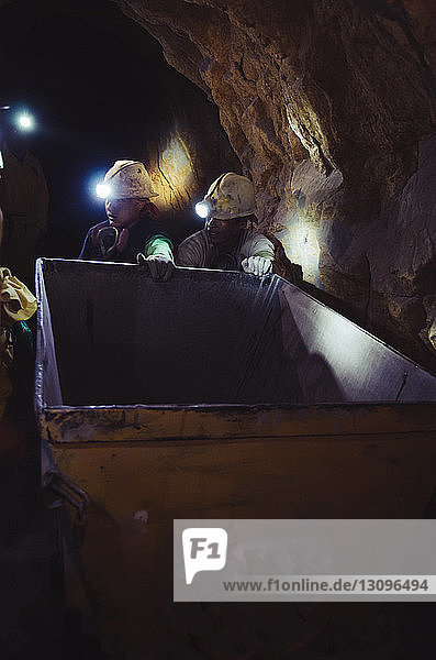 Arbeiter halten Container in einer Höhle auf der Baustelle