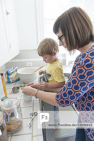 Hochwinkelaufnahme einer Mutter mit Sohn  die zu Hause in der Küche Essen zubereitet