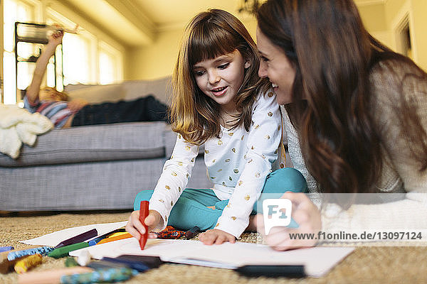 Mother looking at girl drawing on paper