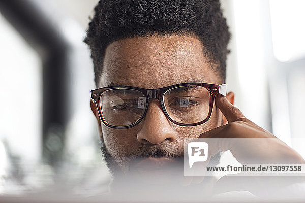 Close-up of concentrated man using laptop at home