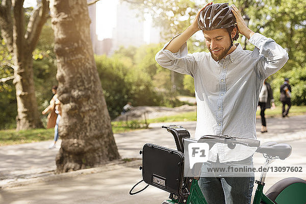 Man wearing cycling helmet while standing in park