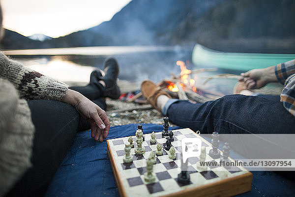 Ausgeschnittenes Bild eines jungen Paares beim Schachspiel am Seeufer