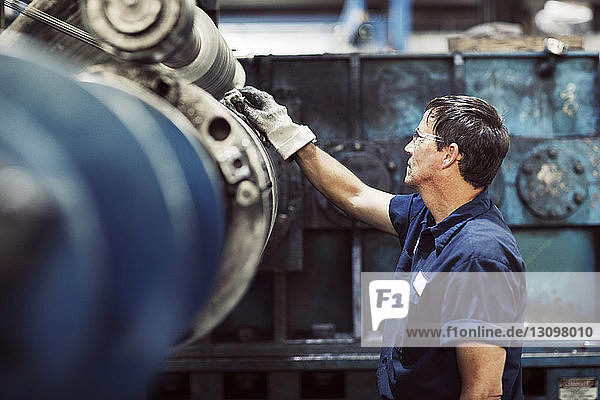 Seitenansicht eines Arbeiters  der Stahlbleche in der Industrie analysiert