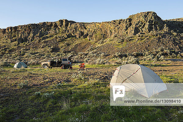 Zelt auf dem Feld am Berg im Gifford Pinchot National Forest mit Geländewagen im Hintergrund