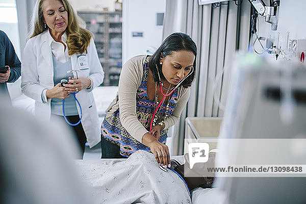 Ärztin bildet Mitarbeiter während der Untersuchung einer Schaufensterpuppe an der medizinischen Fakultät aus