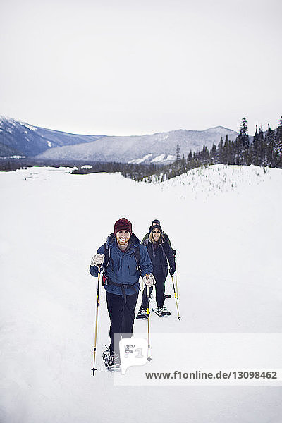 Porträt einer Frau mit ihrem erwachsenen Sohn beim Schneeschuhlaufen