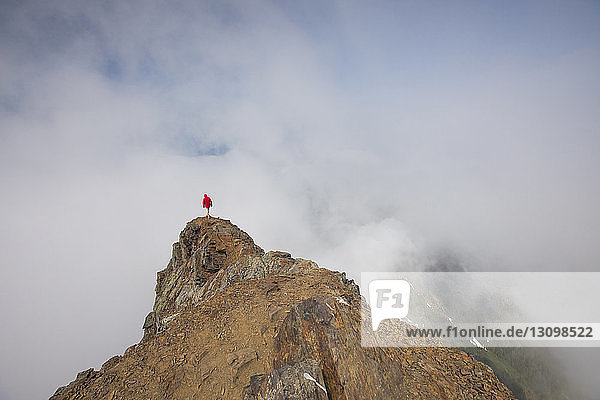 Hochwinkelaufnahme eines Mannes  der auf dem Cheam Peak vor bewölktem Himmel steht
