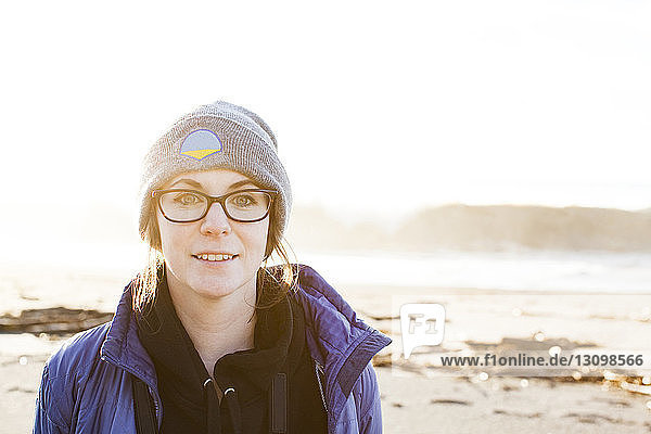 Porträt einer lächelnden Frau  die am Strand vor klarem Himmel an einem sonnigen Tag steht