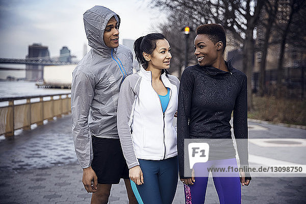 Glückliche multiethnische Athleten im Gespräch auf dem Fußweg
