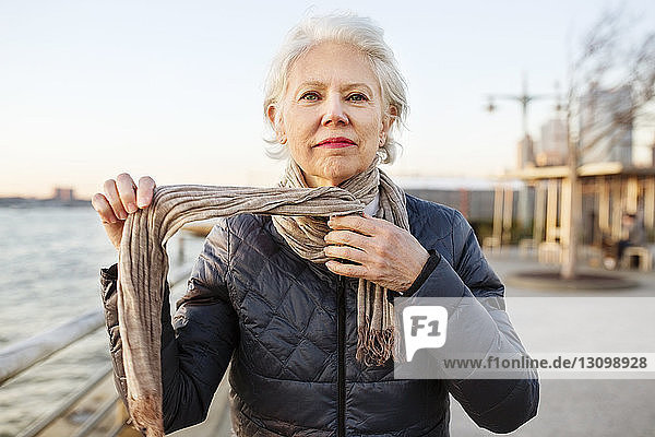 Porträt einer selbstbewussten älteren Frau mit Schalldämpfer auf der Promenade bei Sonnenuntergang