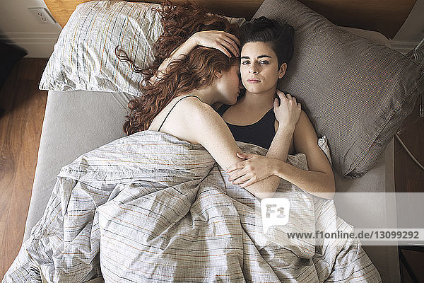 Hochwinkelporträt einer Lesbe mit Freundin  die sich zu Hause auf dem Bett ausruht