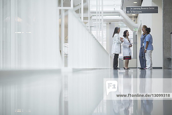 Ärztinnen diskutieren im Stehen im Krankenhauskorridor