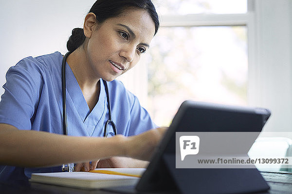 Female doctor using tablet computer while working in medical clinic