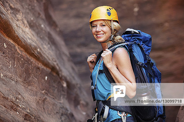 Porträt einer lächelnden Frau an einem Berg stehend