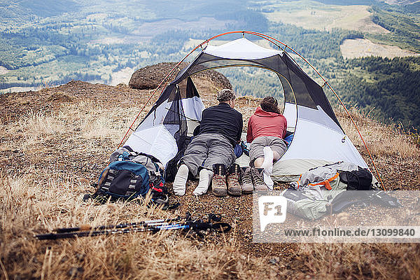 Couple lying in tent on mountain