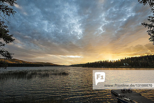 High angle view of chairs on pier by Lac Le Jeune lake at Paul Lake Provincial Park against sky during sunset