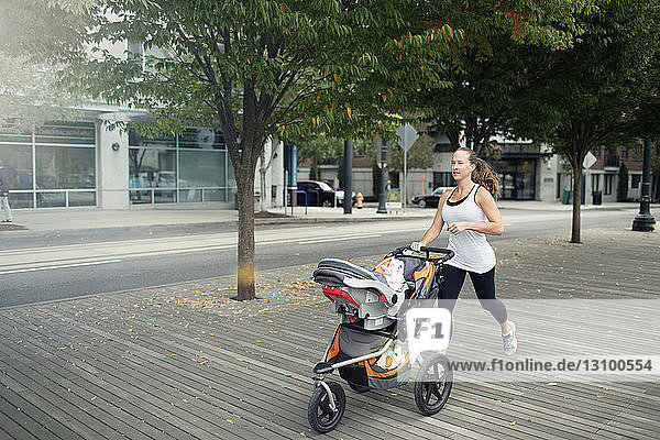 Woman pushing baby stroller while running on floorboard
