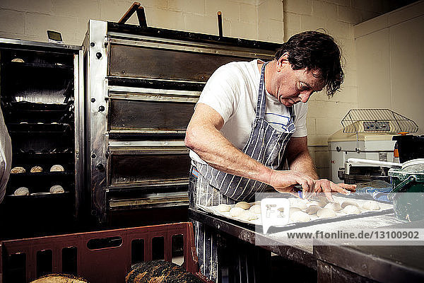 Männlicher Bäcker  der in einer Großküche arbeitet