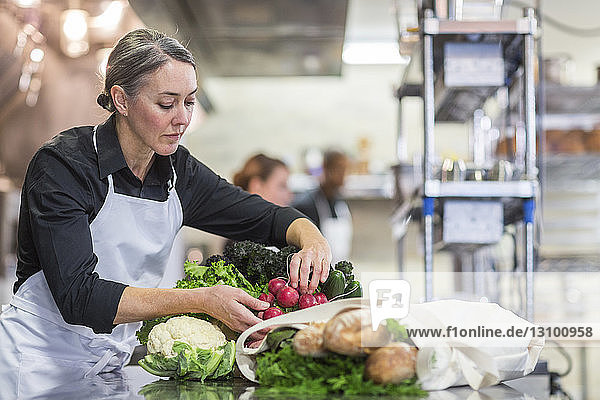 Female chef preparing vegetables in restaurant kitchen
