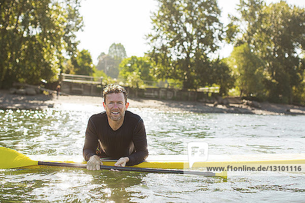 Porträt eines lächelnden Mannes beim Paddelbootfahren auf einem Fluss