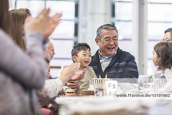 Family celebrating senior man's birthday in restaurant