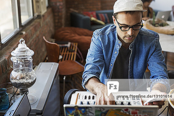 Man using mobile phone with piano at home