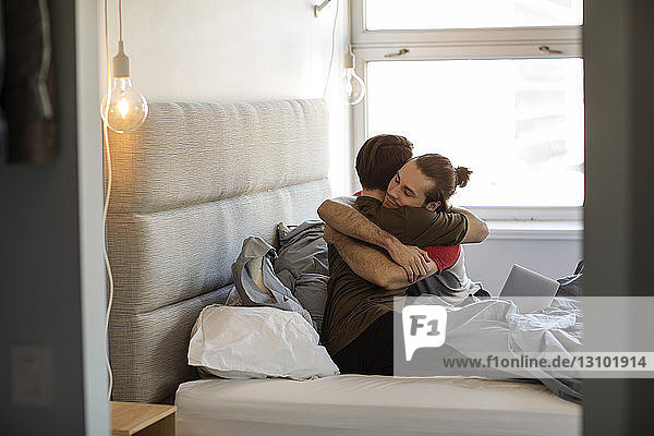Homosexuelles Paar umarmt sich zu Hause im Bett