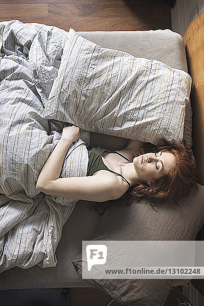 Hochwinkelansicht einer Frau  die zu Hause auf dem Bett schläft