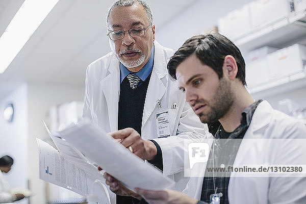 Male doctors discussing reports in hospital