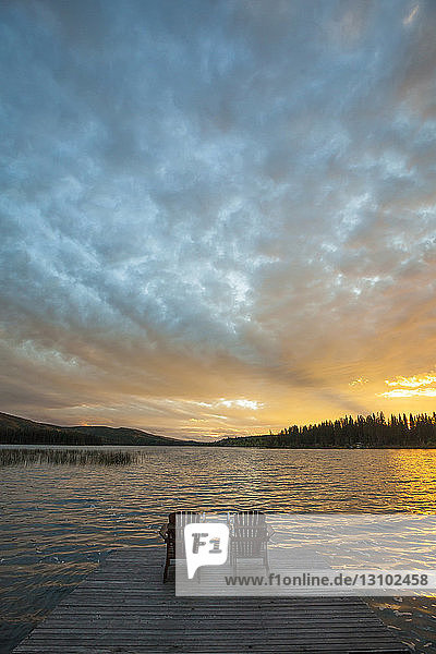 High angle view of chairs on pier by Lac Le Jeune lake at Paul Lake Provincial Park during sunset