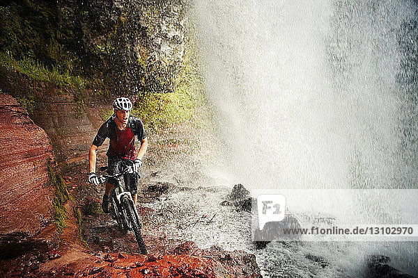 Man cycling at waterfall
