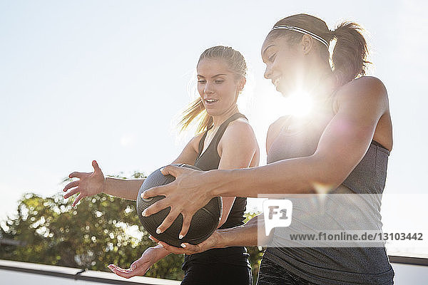 Friends exercising with medicine ball on building terrace