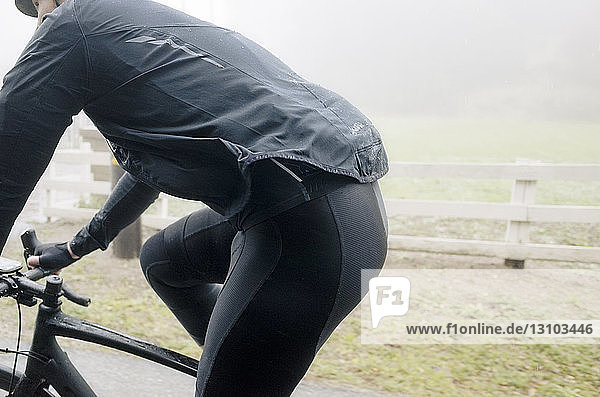 Seitenansicht eines Mannes beim Fahrradfahren bei nebligem Wetter
